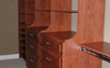 After picture of new closet sytem, two hutches and combination towers with shelves and hanging. Warm Cognac  color- Raised Panel Finish.